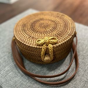 Basket weave cross body purse with floral design on the inside.